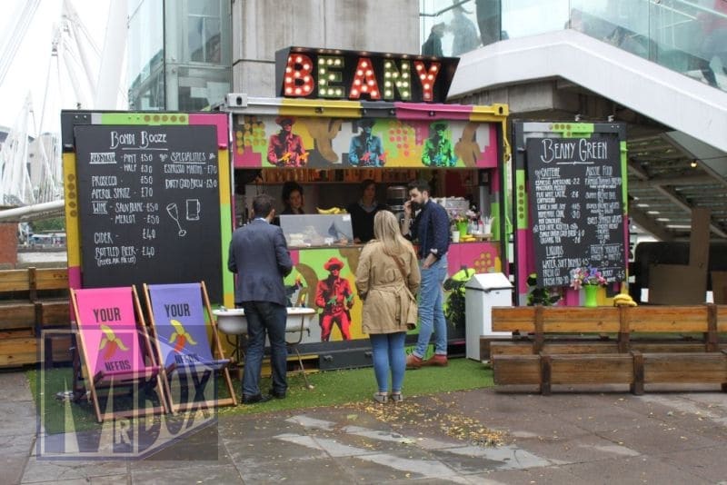 A pop up shop seeling refreshments from a converted container.