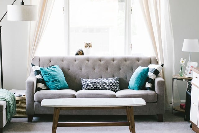 A sofa in a lightly lit living room. A coffee table is in the foreground.